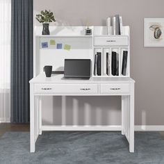 a white desk with a laptop on top of it and bookshelf in the background