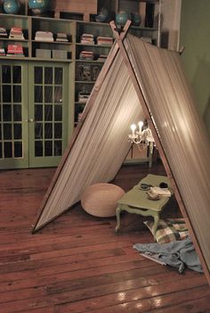 a living room with a teepee tent on the floor