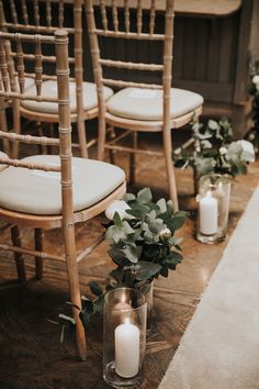 the chairs are lined up with candles and greenery