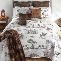 the bed is made with brown and white comforters, pillows, and throw blankets