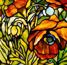 a stained glass window with flowers and leaves