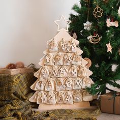 a christmas tree made out of wooden letters and numbers is next to a gift bag