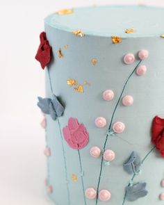 a blue cake decorated with pink and red flowers