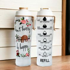 two water bottles sitting next to each other on a wooden table with the words, don't hurry be happy