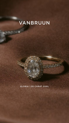 two engagement rings sitting on top of a brown cloth with the words van brun