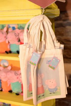 two bags with peppa pig images hanging from them on shelves in a store or children's room