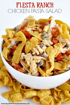 chicken pasta salad in a white bowl with tortilla chips and tomatoes on the side