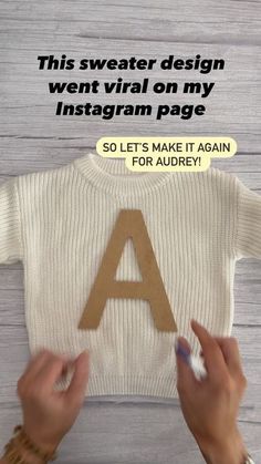 someone is holding up a t - shirt with the letter a in front of it