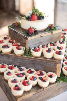 three tiered trays with cupcakes and berries on them