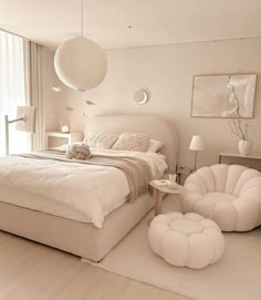 a large white bed sitting in a bedroom next to a window