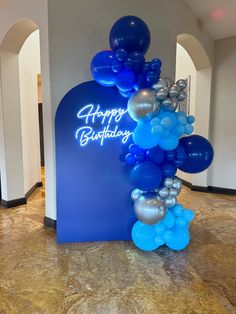 blue and silver balloon arch with happy birthday sign