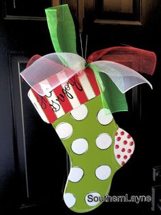 a christmas stocking hanging from the front door with polka dots and green stockings on it