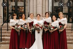 a group of women standing next to each other wearing red dresses and fur stoles