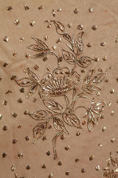 an embroidered fabric with flowers and leaves is shown in this close up photo, it appears to be beading