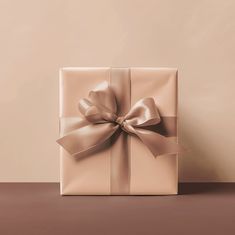 a wrapped gift box with a large bow on the top, sitting on a table