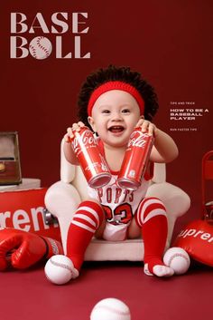 a baby is sitting on a chair with baseballs and coca - cola cans in front of it