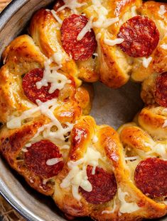 a pepperoni pizza bundt cake in a metal pan on top of a wooden table