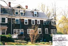 an old black house with white trim and windows