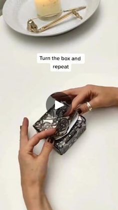 two pictures showing how to open a box and place it on a plate with a candle