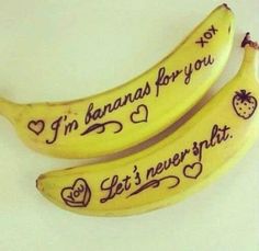 two bananas with writing on them sitting next to each other