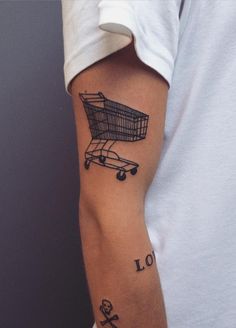 a man's arm with a shopping cart tattoo on it