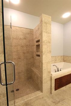 a bathroom with a walk in shower next to a bath tub