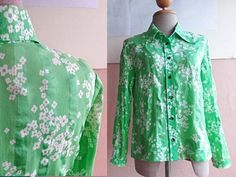 "This cotton blouse is in green cotton cotton with cute floral print. Classic 70s mod shirt collars Darts at chest Vintage Button front entry All original buttons are in place. Long sleeves. Very lightweight. Actual color may be slightly different than shown. CONDITION: very good vintage condition In Measurements(taken flat): Shoulders: 15\" Bust: 18\" Waist : 17\" Total Length: 25\" Sleeve length : 21\" Freshly cleaned and ready to wear To see more items, visit : www.RetroTheory.etsy.com" Green Collared Top With Floral Print, Green Floral Print Top With Collar, Green Collar Blouse For Spring, Green Fitted Printed Shirt, Fitted Green Printed Shirt, Green Printed Blouse For Daywear, Green Floral Print Button-up Shirt, Green Collared Shirt For Spring, Vintage Green Button-up Shirt