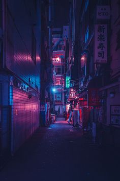 an alley way with neon lights and signs on the buildings