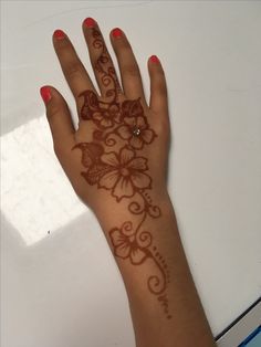 a woman's hand with hendix on it and flowers painted on the palm