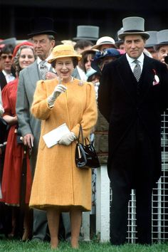 an older man and woman standing next to each other in front of a group of people