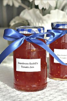 two jars filled with jam sitting on top of a table