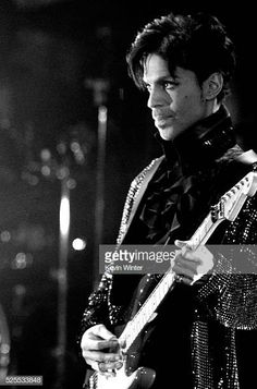 a black and white photo of a man playing an electric guitar