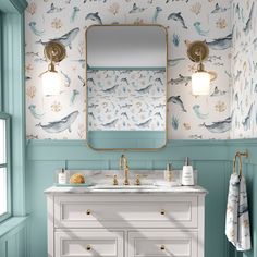 a bathroom with blue and white wallpaper, gold faucet, sink and mirror