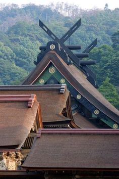 the roof tops of some buildings with mountains in the background