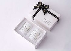 an open gift box with two candles in it