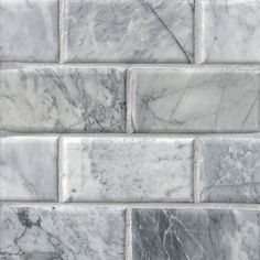 white marble tiles with grey veining on the sides and gray groutes in the middle