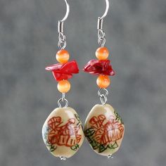 "The crocheted wiring necklace is handmade using hand painted ceramic, red coral, cat eye; with Sterling silver hook. A unique color palette of coral, peach and golden brown. Coral is vibrant and punchy, peach is soft and feminine, gold is luxury and elegant. The meaning of the Chinese writing on the ceramic is \"The flower is blossoming, the fortune is coming\". Who can resist this temptation? The length of the necklace is 17-19 inches, 43-48cm. The length is well suited to crew and high neckli Handmade Coral Round Jewelry, Handmade Round Coral Jewelry, Handmade Red Coral Necklace Gift, Colorful Beads Resin Jewelry Gift, Handmade Red Coral Jewelry, Handmade Red Coral Dangle Jewelry, Handmade Artisan Resin Jewelry, Handmade Red Coral Jewelry As Gift, Bohemian Polymer Clay Round Jewelry