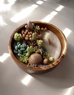 a wooden bowl filled with lots of succulents