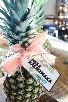 a pineapple with a pink ribbon tied around it