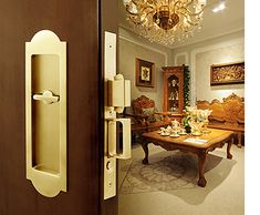 an open door leading to a living room with chandelier hanging from the ceiling