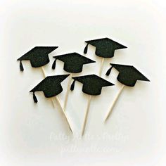 five black graduation hats on top of toothpicks