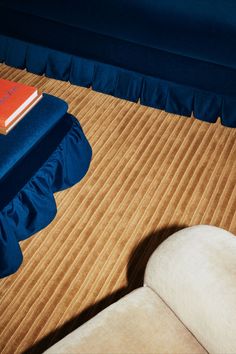 a book sitting on top of a bed next to a white chair and blue sheets