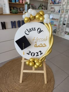 a class of 202 sign with gold balloons and a black graduation cap on it's back