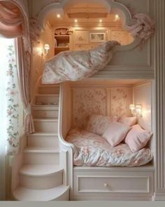 a white bunk bed sitting under a window next to a stair case in a bedroom