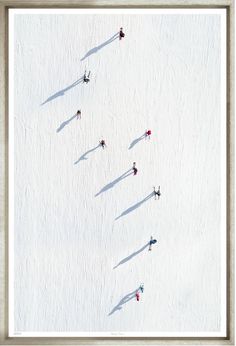 aerial view of skiers skiing down a snow covered slope in the wintertime with long shadows on the ground