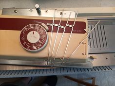 an old fashioned clock sitting on top of a metal shelf next to a heater