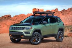 a green jeep parked in the desert with its roof rack on it's top