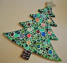 a mosaic christmas tree is displayed on a table