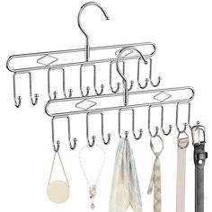 a bunch of clothes hanging from hooks on a wall next to a pair of scissors