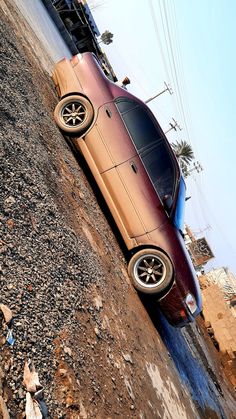 a red car parked on top of a dirt hill